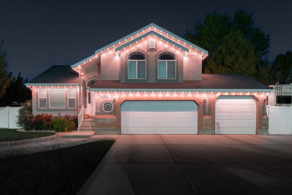 Home with warm white and red lights under the eaves